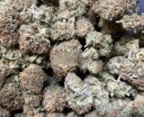 Close-up of Pinkman Goo cannabis buds with purple hues, orange hairs, and glistening trichomes