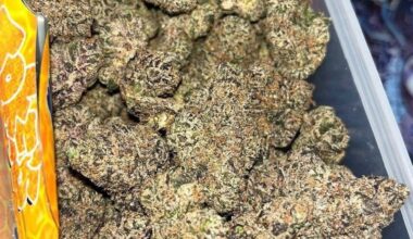 Frosty Honey Combs cannabis buds with golden trichomes and sweet aroma